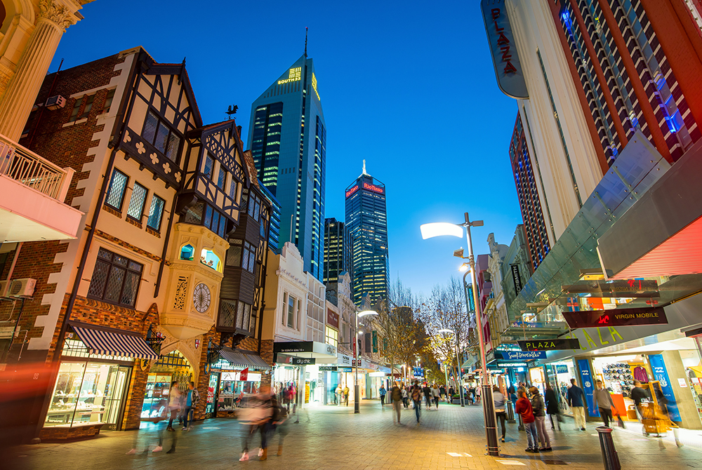 Twilight scene in Perth’s Hay Street Mall with people walking among retail shops.